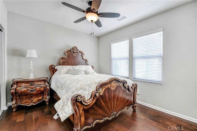 bedroom with a ceiling fan, wood-type flooring, visible vents, and baseboards