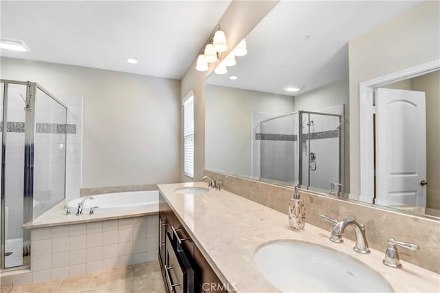 bathroom with double vanity, a stall shower, a garden tub, and a sink