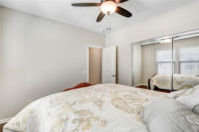 bedroom with ceiling fan, baseboards, and a closet