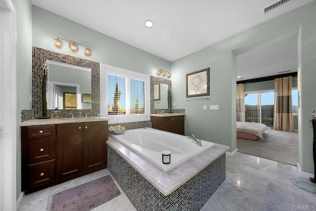 bathroom featuring a garden tub, connected bathroom, two vanities, visible vents, and baseboards