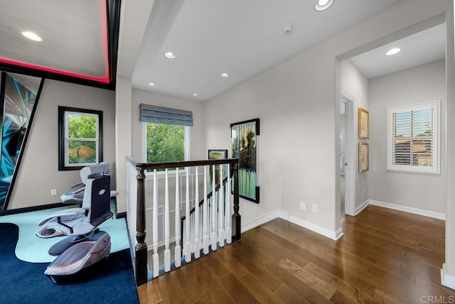 corridor featuring recessed lighting, baseboards, dark wood-style flooring, and an upstairs landing