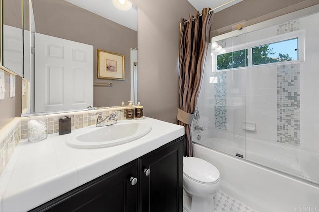 bathroom featuring enclosed tub / shower combo, vanity, and toilet