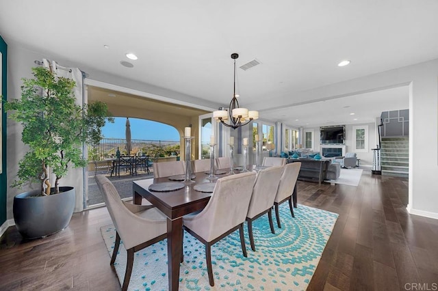 dining area with recessed lighting, a notable chandelier, visible vents, stairway, and dark wood finished floors