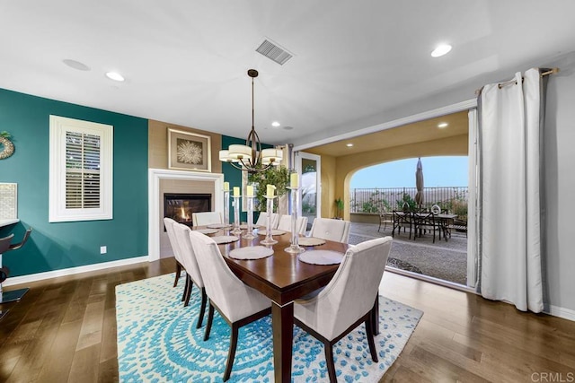 dining room with an inviting chandelier, baseboards, visible vents, and dark wood finished floors