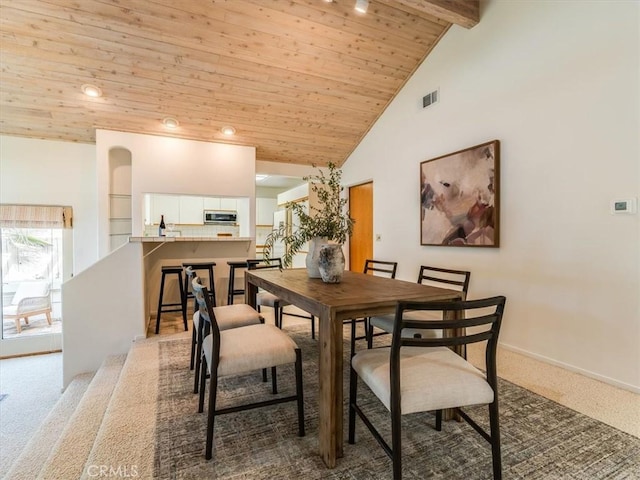 carpeted dining room featuring high vaulted ceiling, wood ceiling, visible vents, baseboards, and beam ceiling