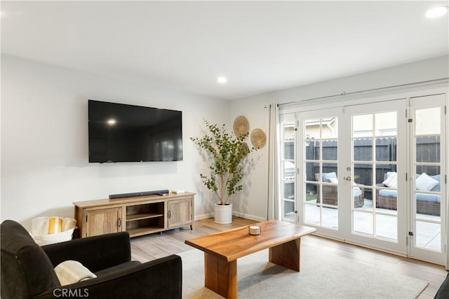 living area featuring light wood-style floors, recessed lighting, and baseboards