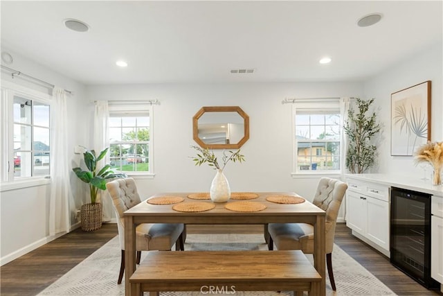 dining space with beverage cooler, plenty of natural light, and dark wood finished floors