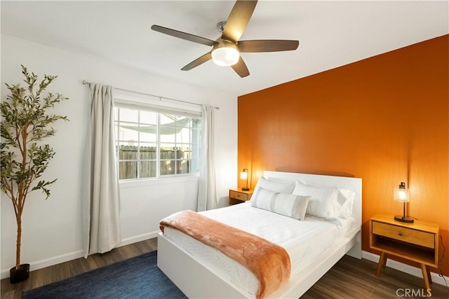 bedroom featuring ceiling fan, wood finished floors, and baseboards