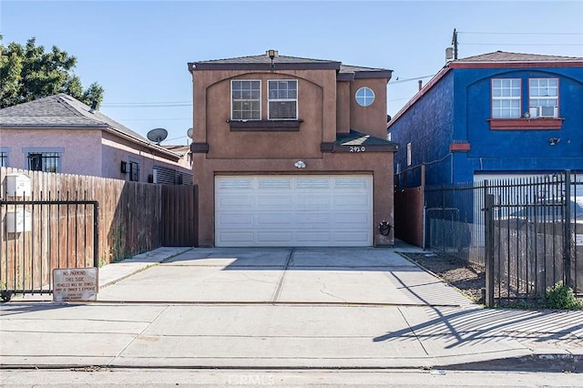 traditional home with concrete driveway, an attached garage, fence, and stucco siding