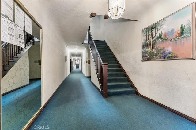 stairway featuring carpet flooring, a textured wall, and baseboards