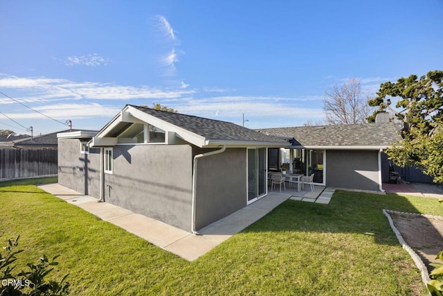 back of house with a yard, a patio, fence, and stucco siding