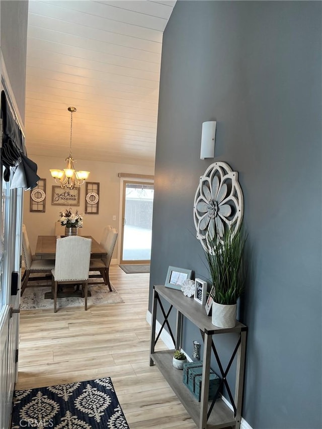 interior space featuring light wood-type flooring, wooden ceiling, and a notable chandelier