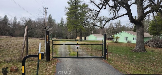 view of gate with a lawn