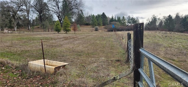 view of yard featuring a rural view and fence