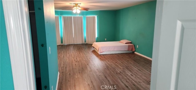 unfurnished bedroom with baseboards and wood finished floors