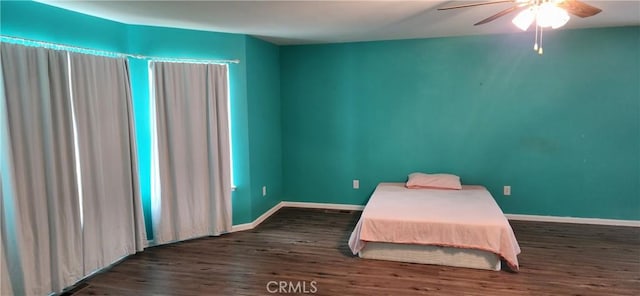 bedroom featuring dark wood-type flooring, ceiling fan, and baseboards