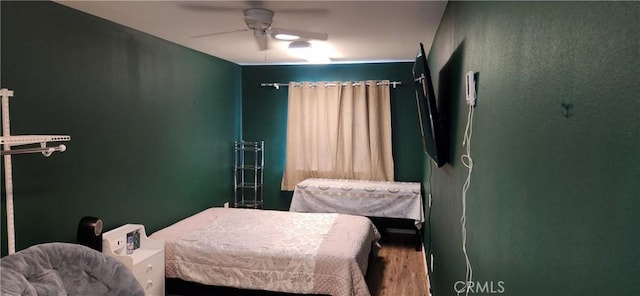 bedroom with a ceiling fan and wood finished floors