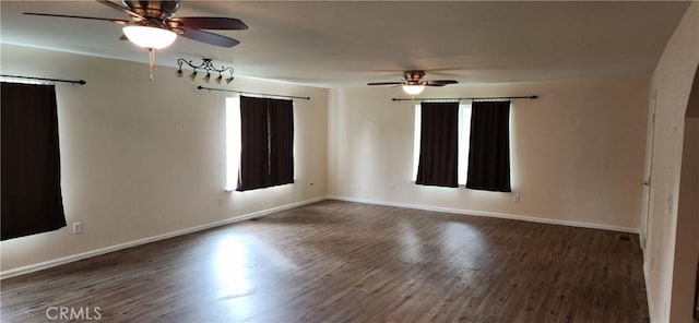 spare room with ceiling fan, plenty of natural light, baseboards, and wood finished floors