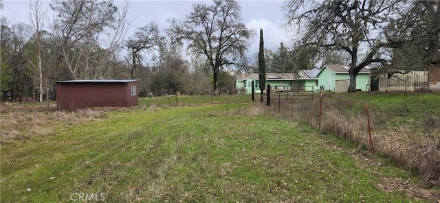 view of yard featuring an outbuilding and fence