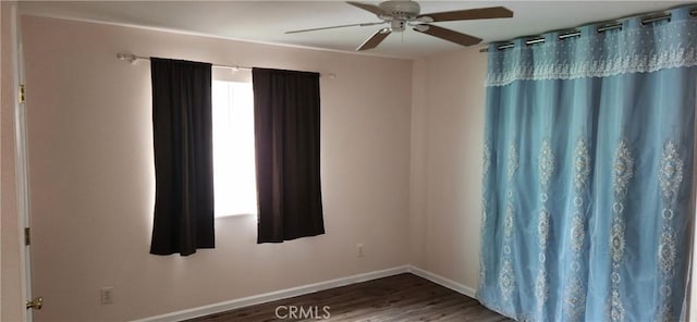 empty room featuring ceiling fan, baseboards, and wood finished floors