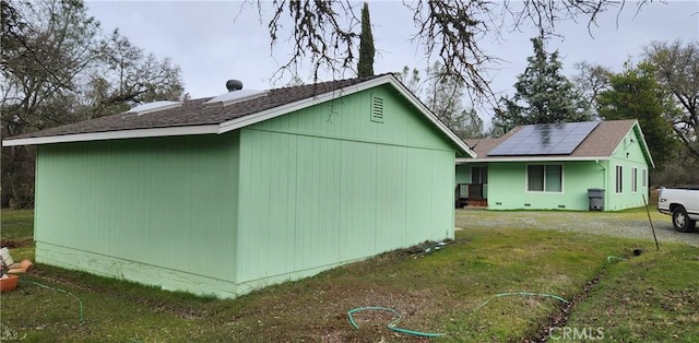 exterior space with solar panels and a lawn