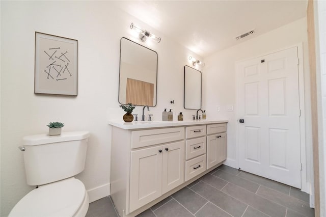 bathroom featuring double vanity, visible vents, toilet, tile patterned floors, and a sink