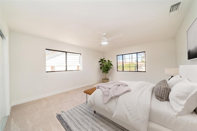 bedroom with baseboards, ceiling fan, visible vents, and light colored carpet