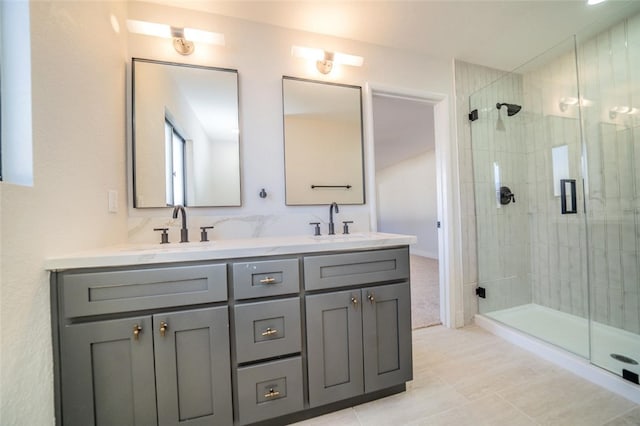 full bath featuring double vanity, a shower stall, and a sink