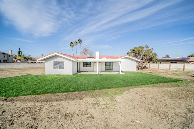 back of house featuring stucco siding, a lawn, fence, and a patio