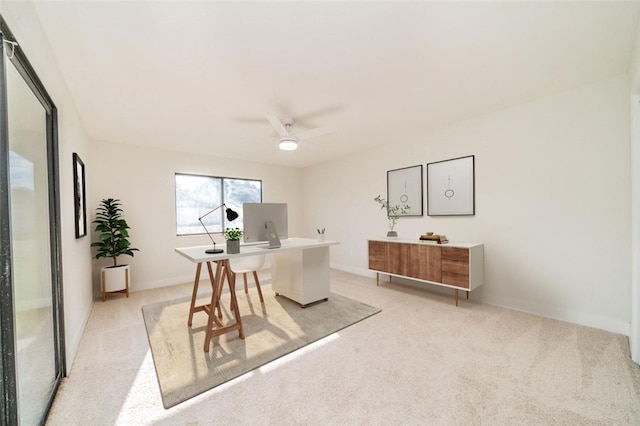 office space with a ceiling fan and light carpet