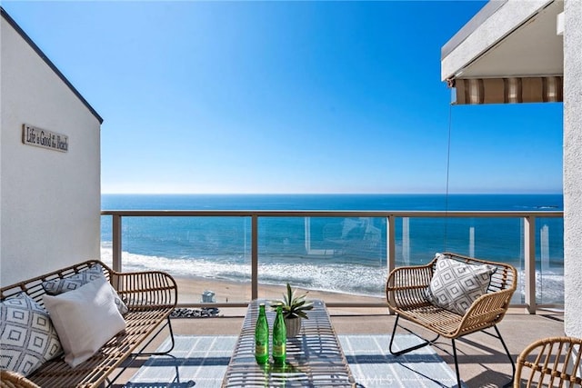 balcony featuring a beach view and a water view