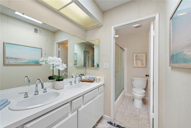 bathroom featuring toilet, tile patterned flooring, a sink, and visible vents