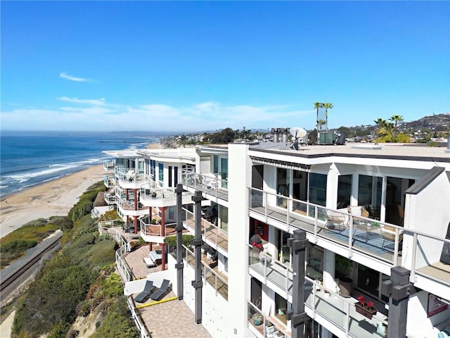 view of building exterior with a water view and a beach view