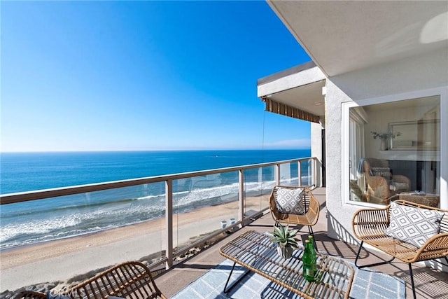 balcony featuring a water view, a sunroom, and a beach view