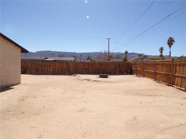 view of yard with a fire pit, fence private yard, and a mountain view