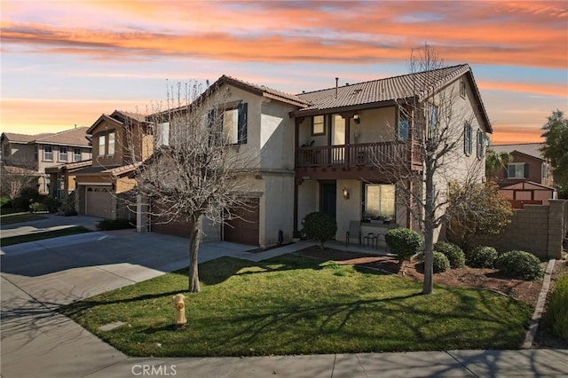 view of front of property featuring driveway, a lawn, a tiled roof, an attached garage, and stucco siding