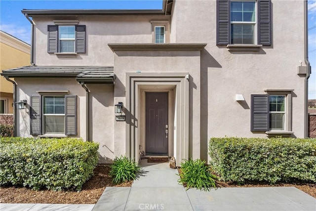 property entrance with stucco siding