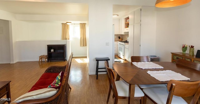 dining room featuring light wood-style floors and baseboards