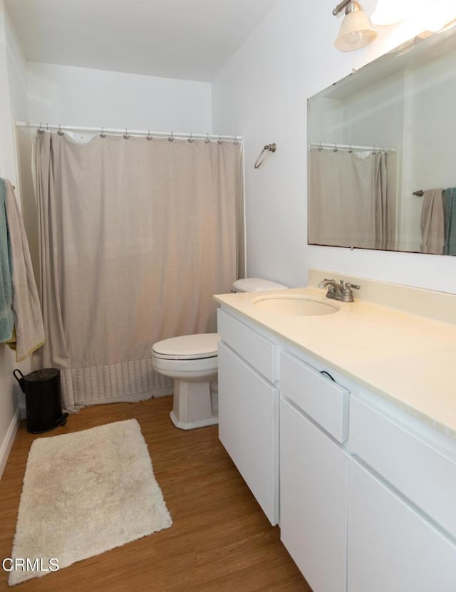 bathroom with vanity, toilet, and wood finished floors