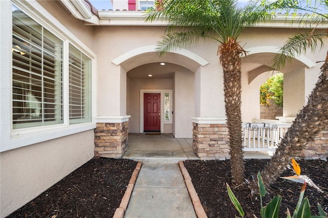 entrance to property with stone siding and stucco siding