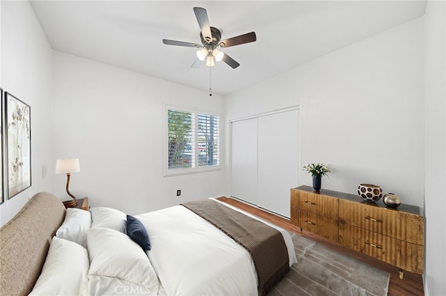 bedroom featuring a ceiling fan, a closet, and dark wood-type flooring