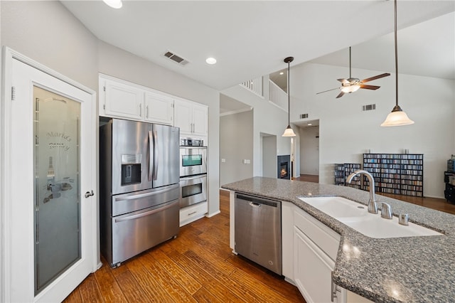 kitchen with stainless steel appliances, white cabinets, a sink, and visible vents