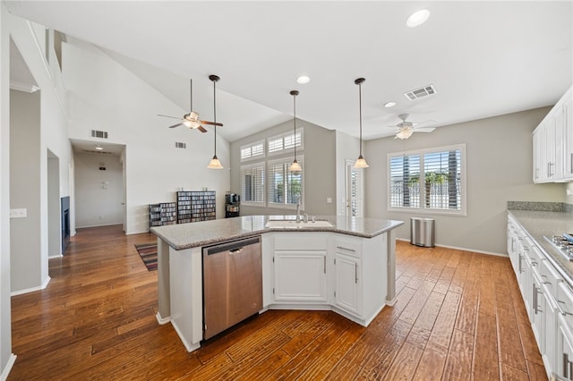 kitchen with a kitchen island with sink, a sink, visible vents, white cabinets, and stainless steel dishwasher