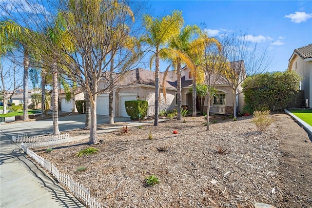 view of property hidden behind natural elements with a garage, driveway, a tile roof, and stucco siding