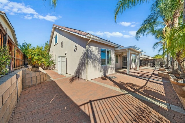 rear view of house featuring a patio area, a fenced backyard, and stucco siding