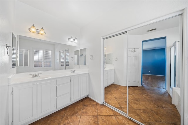 full bath with visible vents, a sink, and double vanity