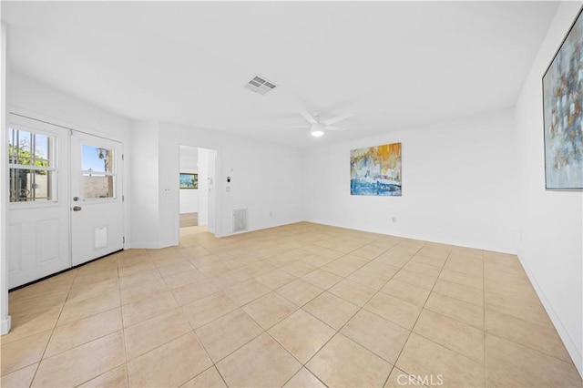 unfurnished room featuring a ceiling fan, visible vents, and light tile patterned flooring