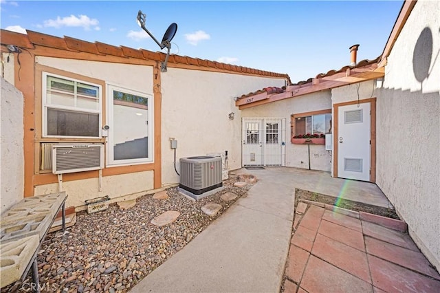 back of house with central AC, a patio, cooling unit, and stucco siding