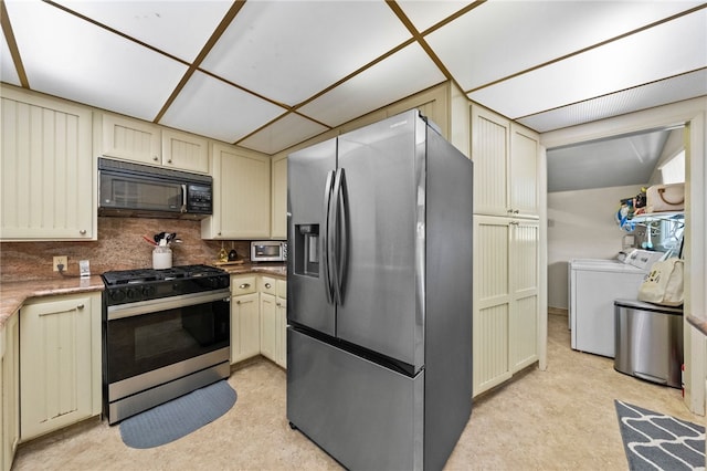 kitchen with appliances with stainless steel finishes, washer and dryer, decorative backsplash, and cream cabinets