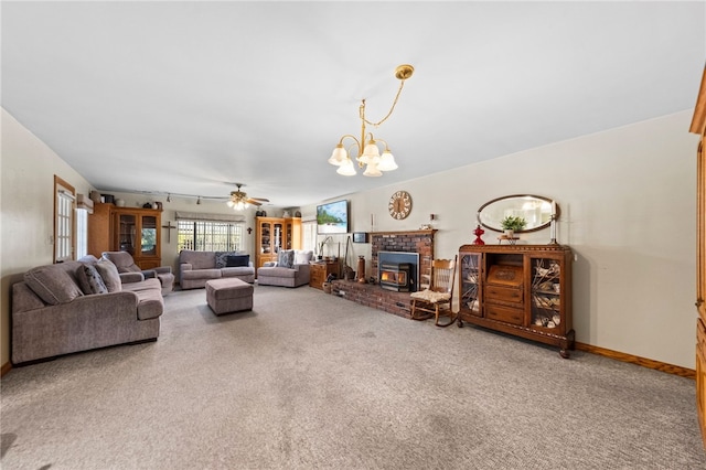 living area with ceiling fan with notable chandelier, track lighting, carpet flooring, and baseboards